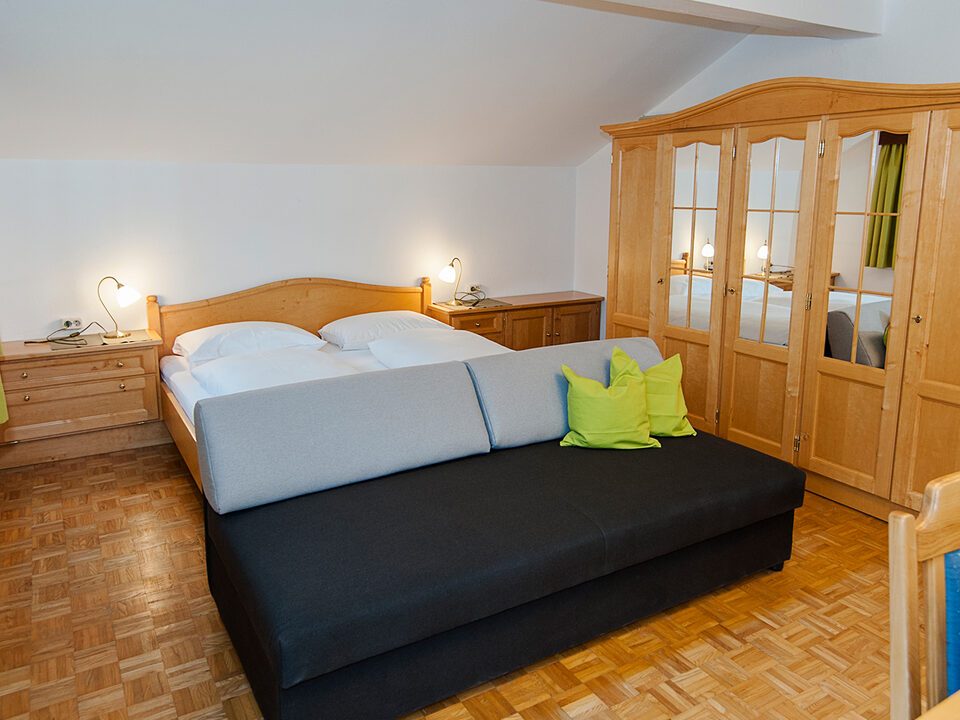 Tweepersoonsbed met bank en spiegelkast