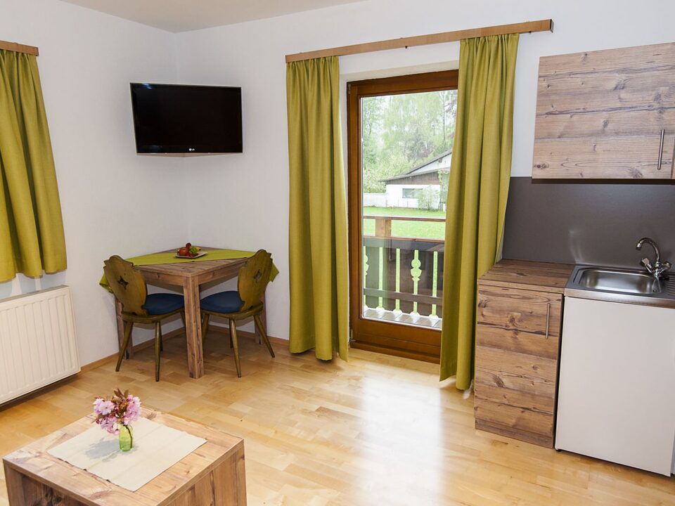 Woongedeelte met kitchenette, eettafel en balkondeur