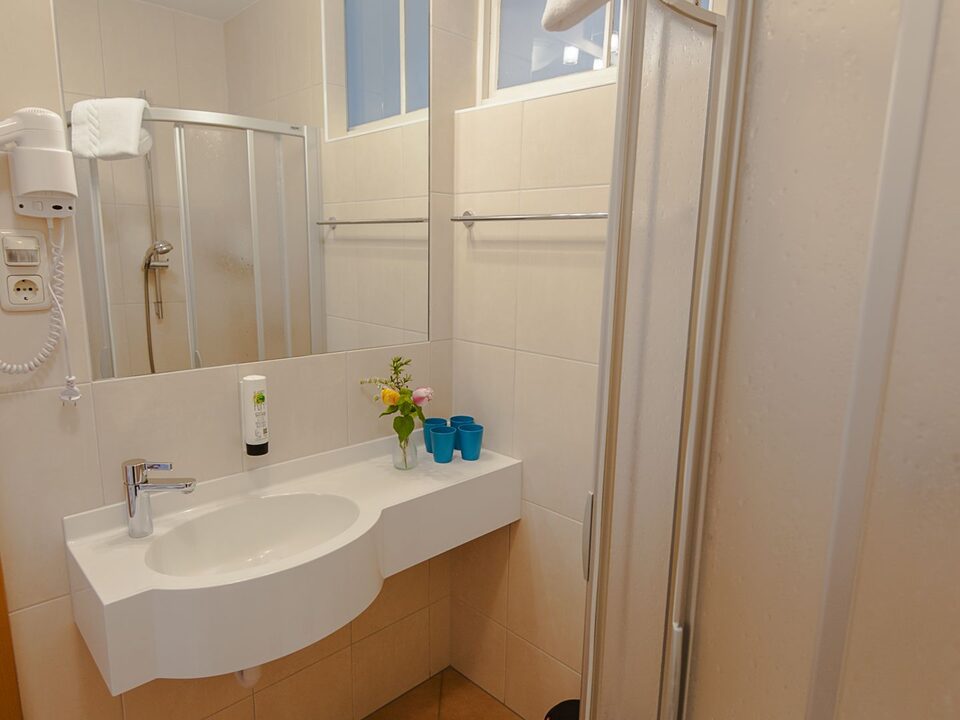 Bagno con lavabo, asciugacapelli e doccia